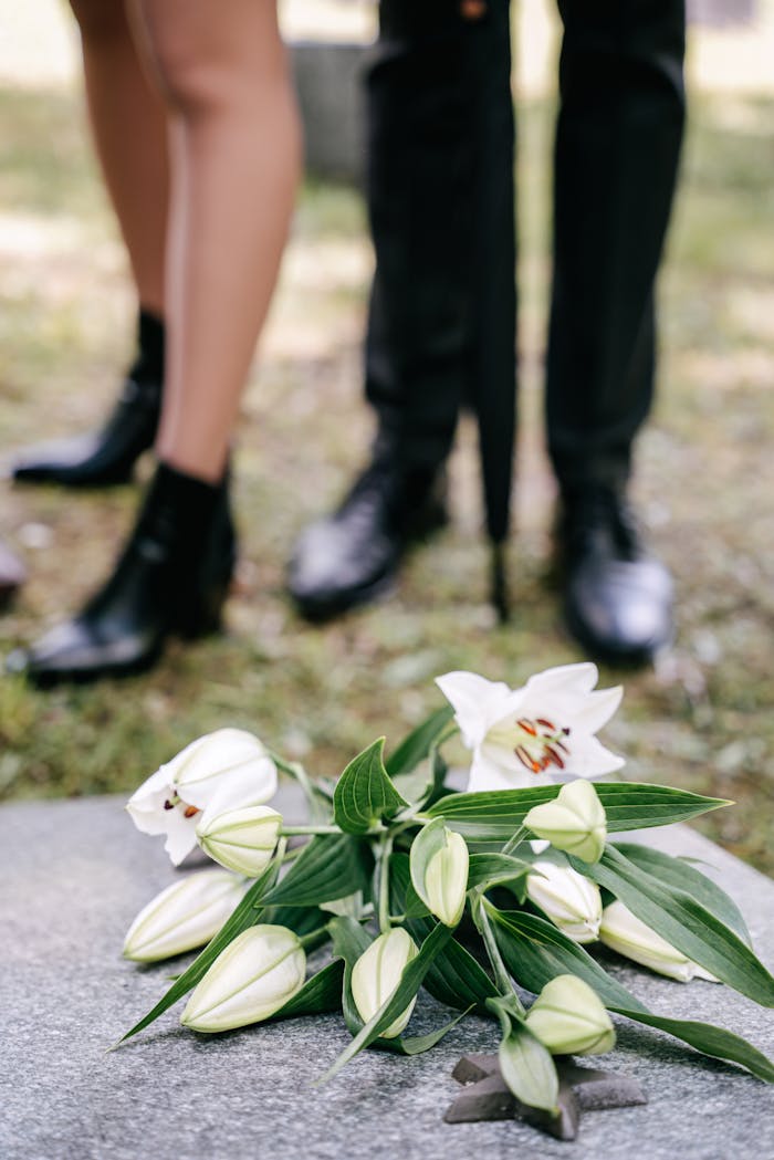 Crafting Captivating Headlines: Your awesome post title goes here White lily flowers on a tombstone, symbolizing grief and loss at a cemetery.